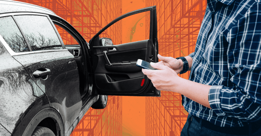 A person holds a phone in front of an open sedan door.